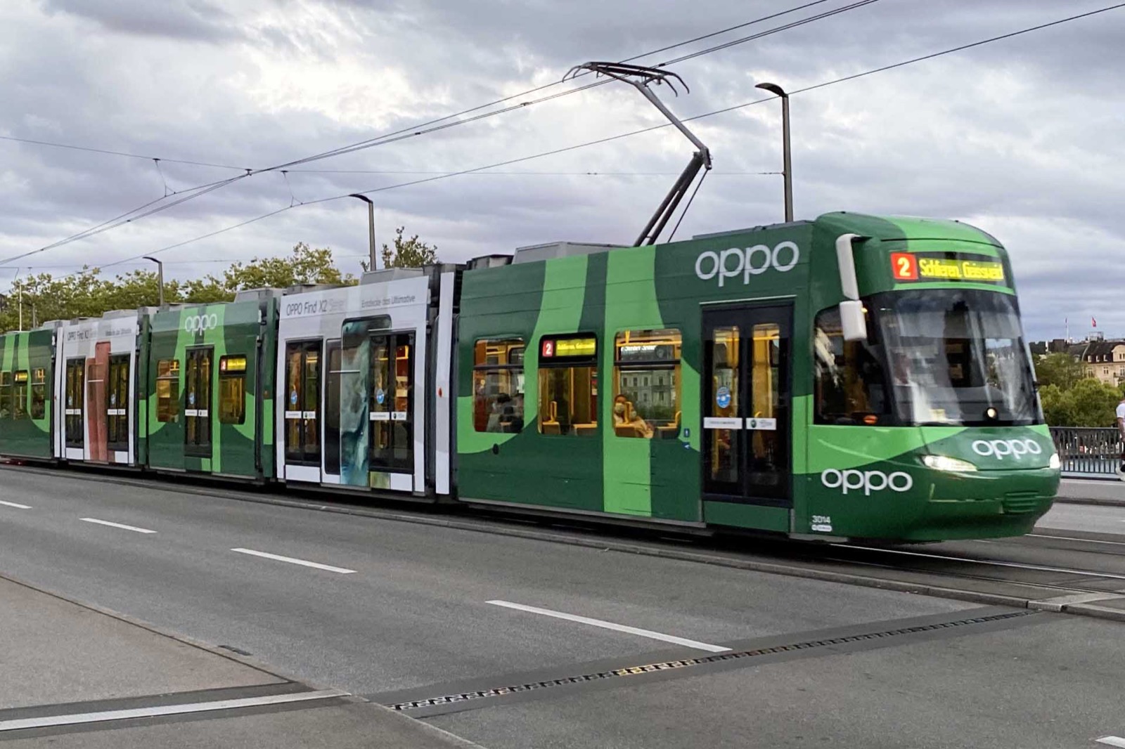 Grünes Tram mit vollflächiger OPPO-Werbung in Zürich