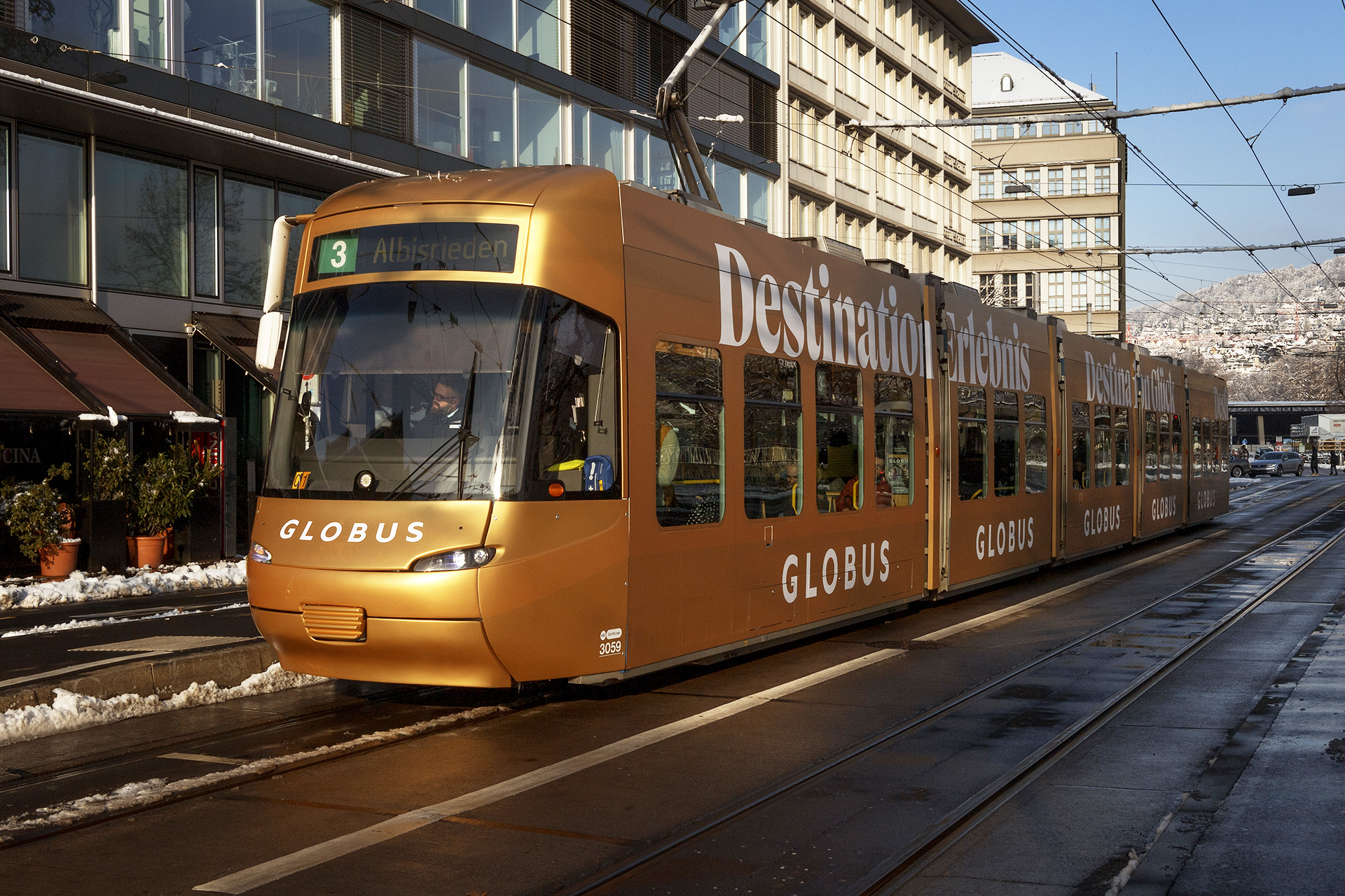 Goldfarbenes Globus-Tram mit vollflächiger Beschriftung in Zürich